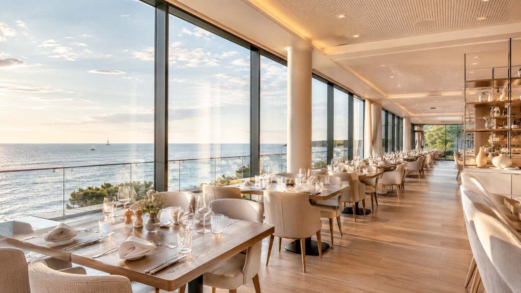 Helles Restaurant an der Ostsee mit Glasfront, eingedeckten Tischen und Meerblick